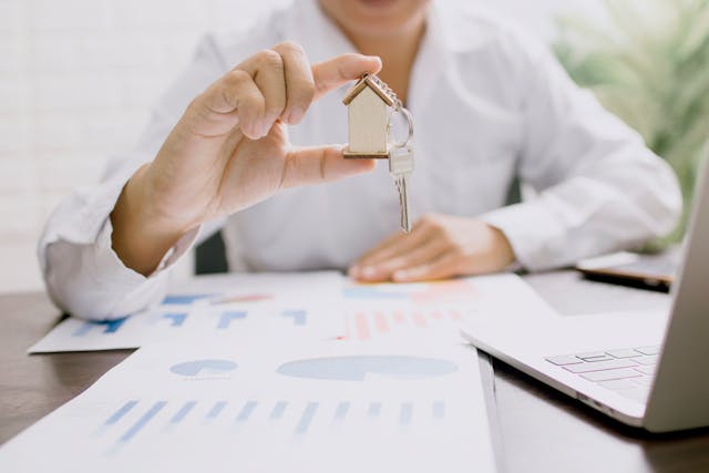a%20person%20holding%20a%20house%20figurine%20and%20key%20with%20documents%20around%20them a%20person%20holding%20a%20house%20figurine%20and%20key%20with%20documents%20around%20them